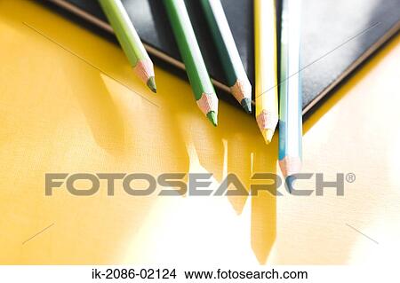 Picture - Colorful pencils lying on drawing book. Fotosearch