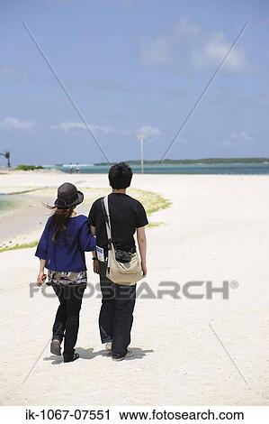 Stock Image - Couple walking on beach. Fotosearch