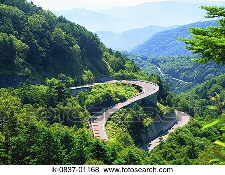 Stock Photo - Curving road passing through forest. Fotosearch