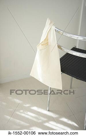 Empty bag hanging on a chair View Large Photo Image Stock Photograph - Empty bag hanging on a chair. Fotosearch