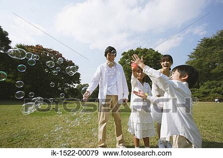 Stock Photo - Family Blowing Bubbles. Fotosearch