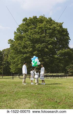 Stock Photography - Family Having Fun With Balloons. Fotosearch