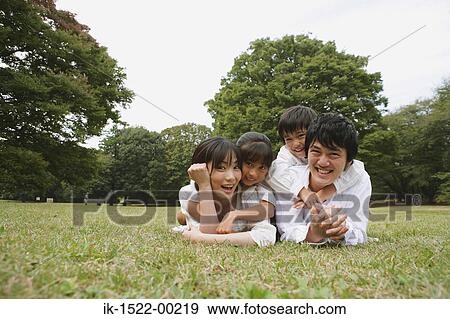 Family Laying Down on Grass View Large Photo Image Stock Photo - Family Laying Down on Grass. Fotosearch