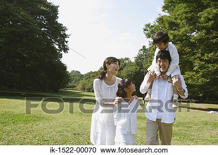 Stock Image - Family Walking in Park. Fotosearch