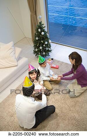 Family wearing party hats with birthday present View Large Photo Image Stock Image - Family wearing party hats with birthday present. Fotosearch