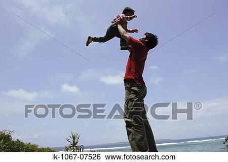 Stock Photograph - Father lifting child into air. Fotosearch