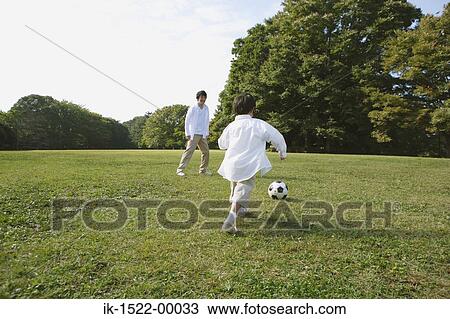 Stock Image - Father Playing Soccer with Son. Fotosearch