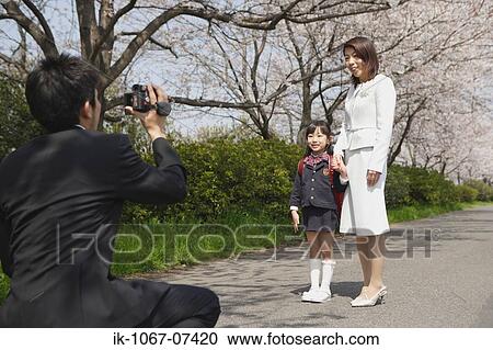 Father taking a family photograph on road View Large Photo Image Stock Image - Father taking a family photograph on road. Fotosearch