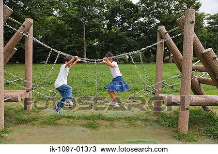 Stock Image - Friends playing together on jungle gym. Fotosearch