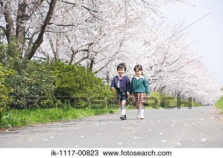 Stock Image - Friends walking on road holding hands. Fotosearch