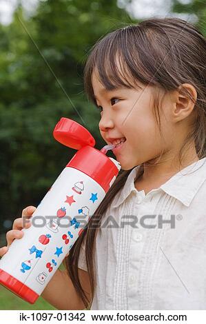 Stock Image - Girl drinking water from water bottle. Fotosearch