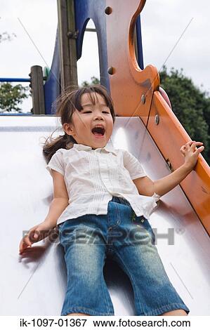 Stock Photo - Girl enjoying on a park slide. Fotosearch