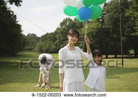 Stock Image - Girl Holding Balloons. Fotosearch