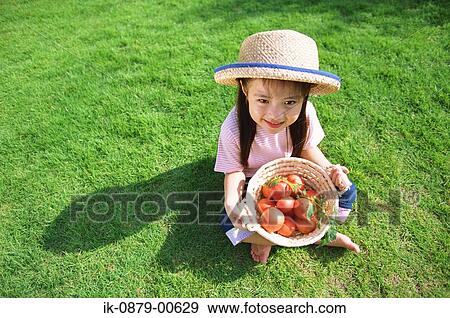 Stock Photo - Girl holding basket of tomatoes. Fotosearch