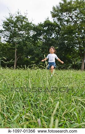 Stock Photograph - Girl playing in a park. Fotosearch