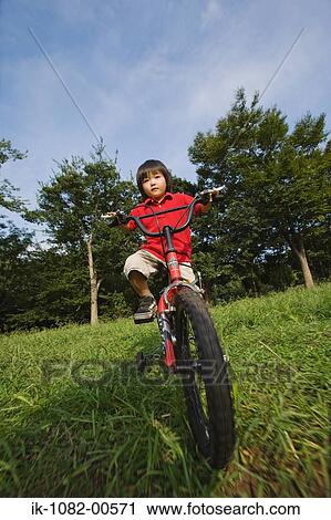 Stock Image - Girl riding bicycle in park. Fotosearch