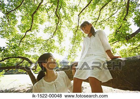 Stock Photo - Girl Sitting in Tree with Mom. Fotosearch