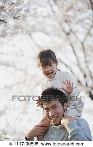 Stock Photography - Girl sitting on her father's shoulders. Fotosearch