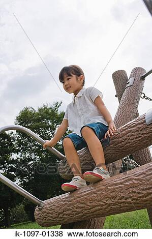Girl sitting on jungle gym in a park View Large Photo Image Stock Photo - Girl sitting on jungle gym in a park. Fotosearch
