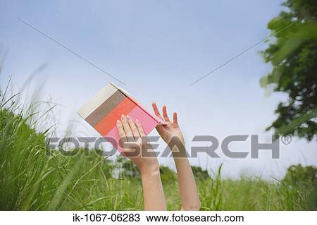 Hands of a person holding book View Large Photo Image Stock Image - Hands of a person holding book. Fotosearch