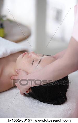Stock Photo - Hands of a person massaging forehead of a woman. Fotosearch