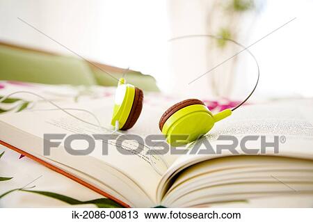 Stock Image - Headphone Kept on Book. Fotosearch