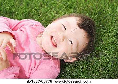 Stock Photo - Japanese baby boy lying on grass. Fotosearch