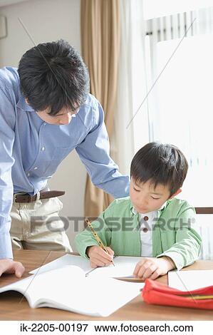 Japanese boy doing homework with his father View Large Photo Image Stock Photo - Japanese boy doing homework with his father. Fotosearch
