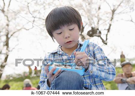 Japanese boy eating sushi with chopsticks View Large Photo Image Picture - Japanese boy eating sushi with chopsticks. Fotosearch