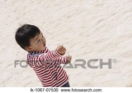 Japanese boy with handful of sand on beach View Large Photo Image Stock Image - Japanese boy with handful of sand on beach. Fotosearch