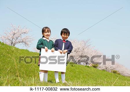 Stock Image - Japanese children holding white cardboard. Fotosearch