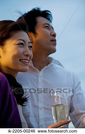 Stock Photograph - Japanese couple having champagne in champagne cup. Fotosearch