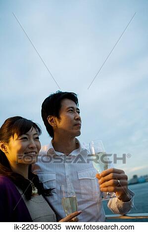 Japanese couple having champagne in champagne cup View Large Photo Image Stock Photography - Japanese couple having champagne in champagne cup. Fotosearch