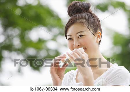 Picture - Japanese eating woman bread. Fotosearch