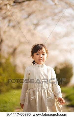 Stock Image - Japanese girl holding flower. Fotosearch