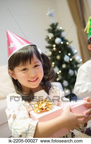 Stock Photo - Japanese girl holding her birthday present. Fotosearch