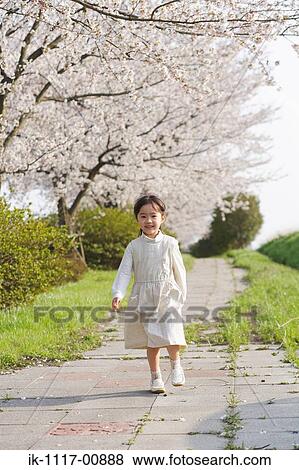 Japanese girl walking alone in a park View Large Photo Image Stock Photo - Japanese girl walking alone in a park . Fotosearch