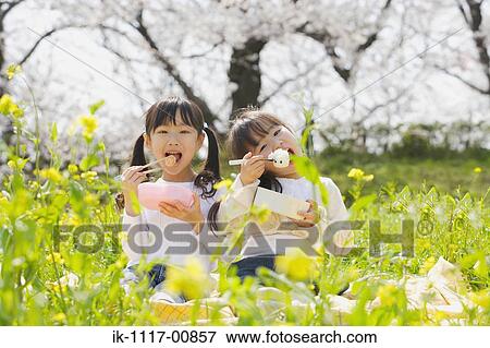 Stock Photo - Japanese girls eating lunch with chopsticks. Fotosearch