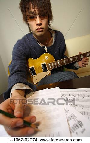Picture - Japanese man composing music. Fotosearch