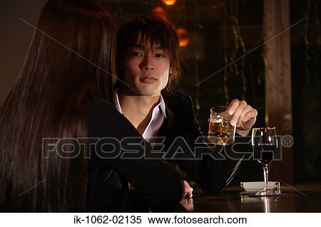 Japanese man holding a drink enjoying company of Japanese woman View Large Photo Image Stock Photography - Japanese man holding a drink enjoying company of Japanese woman. Fotosearch