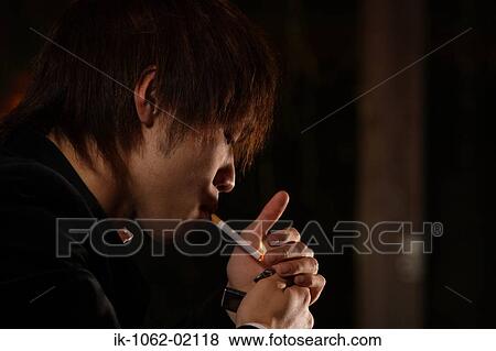 Stock Photo - Japanese man lighting a cigarette. Fotosearch