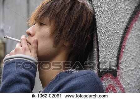 Japanese man smoking while leaning on a wall View Large Photo Image Stock Image - Japanese man smoking while leaning on a wall. Fotosearch