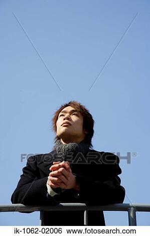 Stock Photograph - Japanese man waiting outside on a nice day. Fotosearch