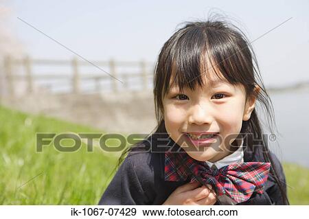 Stock Photo - Japanese schoolgirl smiling and looking at camera. Fotosearch