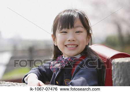 Stock Photograph - Japanese schoolgirl smiling and looking at camera. Fotosearch
