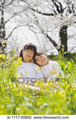 Japanese sisters enjoying together in a park View Large Photo Image Stock Image - Japanese sisters enjoying together in a park. Fotosearch