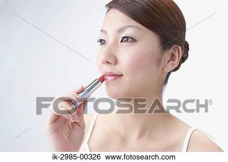 Stock Photograph - Japanese Woman Applying Lipstick. Fotosearch