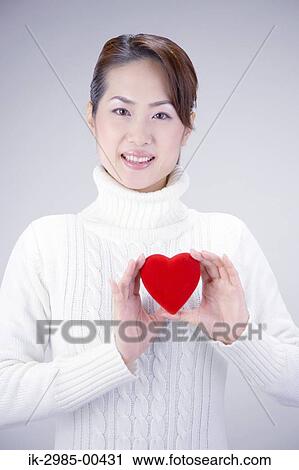 Stock Image - Japanese Woman Holding Heart. Fotosearch