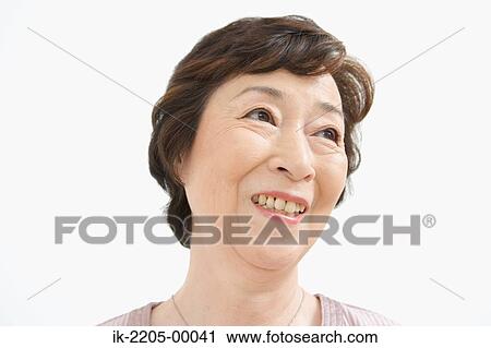 Stock Image - Japanese woman smiling and looking away from camera. Fotosearch