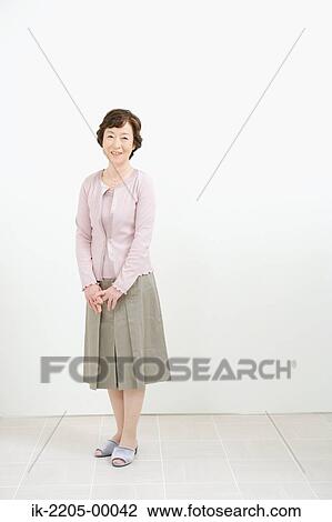 Stock Image - Japanese woman standing in a room. Fotosearch
